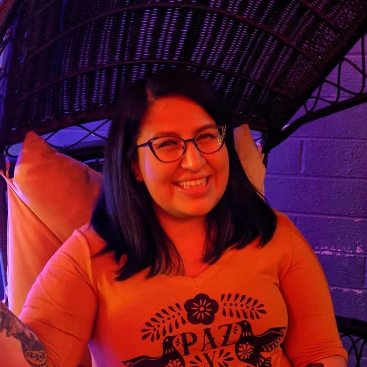 a woman sitting in a hammock with tattoos.