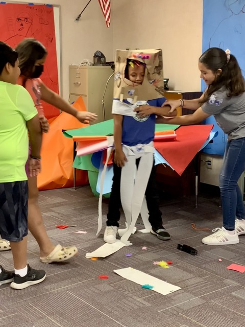 a group of children in a classroom making a cardboard box.