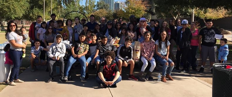 a group of people posing for a picture in a park.