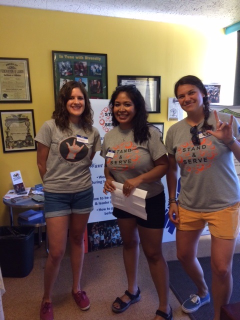 three women in t - shirts standing in a room.