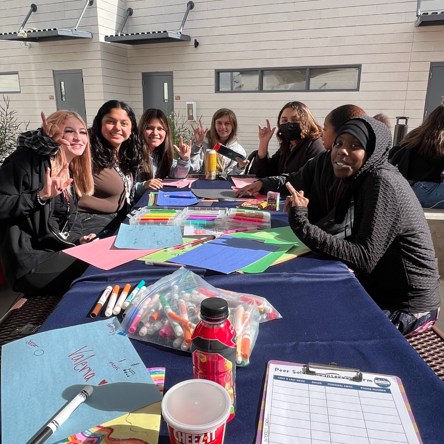 a group of people sitting around a table with crafts.